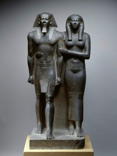 Black diorite sculptures of Mycerinus (Menkaure, builder of the third pyramid at Giza) and his wife. The quality finish and precision, married to perfect posture and physical proportion, illustrate the god like status of Old Kingdom pharaohs.